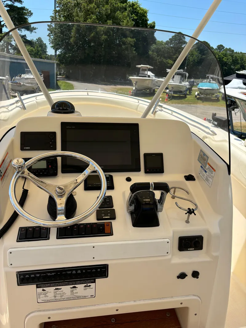 Slide: The Image of 2008 Pursuit S 310 Sport boat dashboard with steering wheel and controls. - 9
