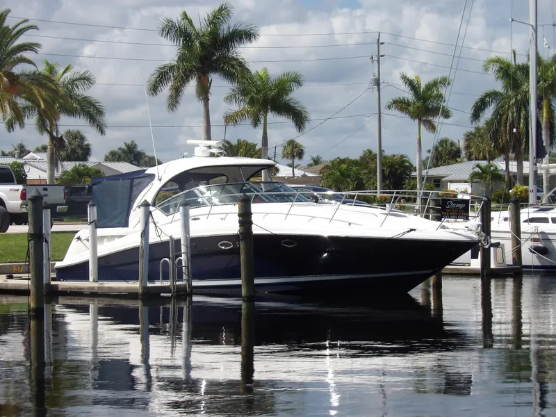 Slide: The Image of 2005 Sea Ray 390 Sundancer docked at a marina with palm trees in the background. - 1