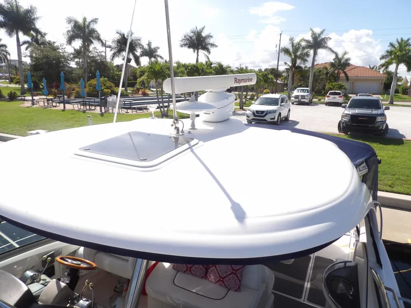 Slide: The Image of 2005 Sea Ray 390 Sundancer boat with Raymarine radar, docked near palm trees. - 12