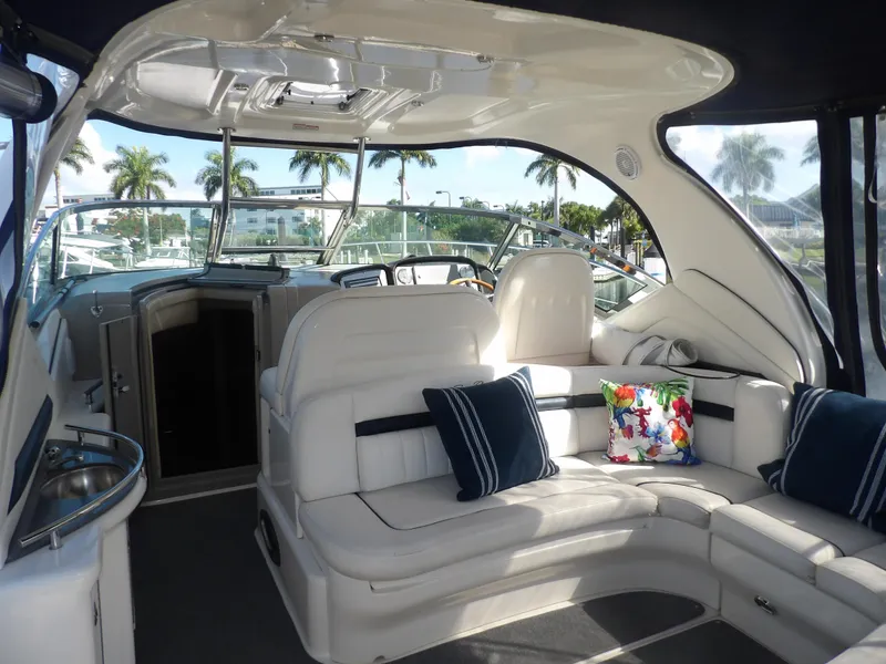 Slide: The Image of 2005 Sea Ray 390 Sundancer interior with white seating and colorful pillows. - 15