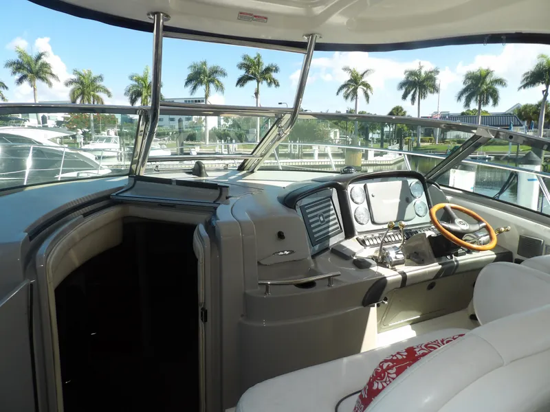 Slide: The Image of 2005 Sea Ray 390 Sundancer helm with modern navigation equipment and palm trees in the background. - 18