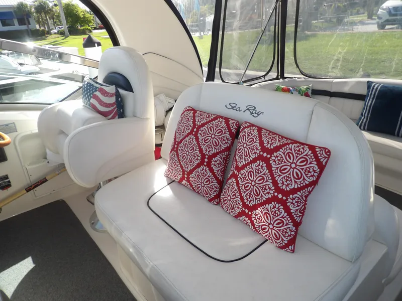 Slide: The Image of 2005 Sea Ray 390 Sundancer interior with white seating and red patterned cushions. - 19