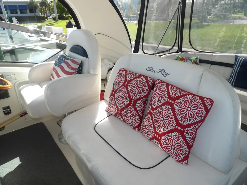 Slide: The Image of Interior seating of 2005 Sea Ray 390 Sundancer with red patterned pillows and American flag cushion. - 20