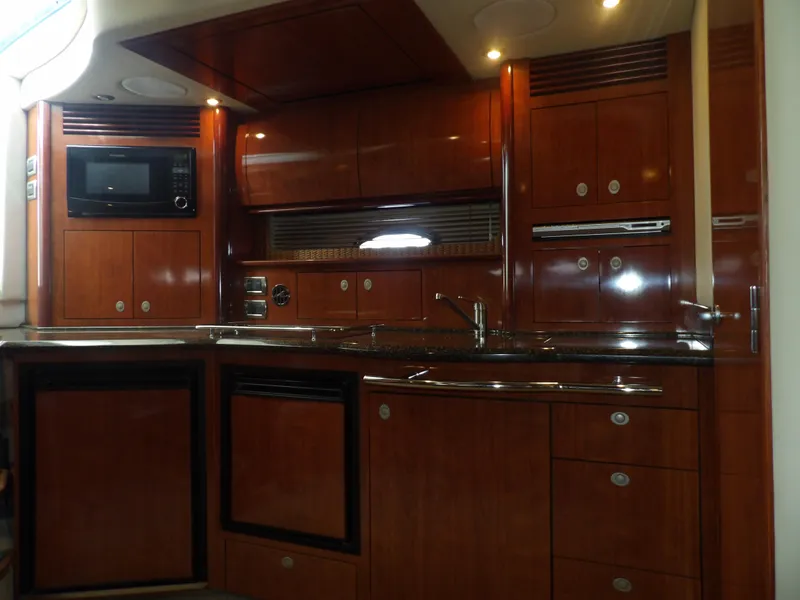 Slide: The Image of Luxurious kitchen area in a 2005 Sea Ray 390 Sundancer yacht with wooden cabinetry. - 36
