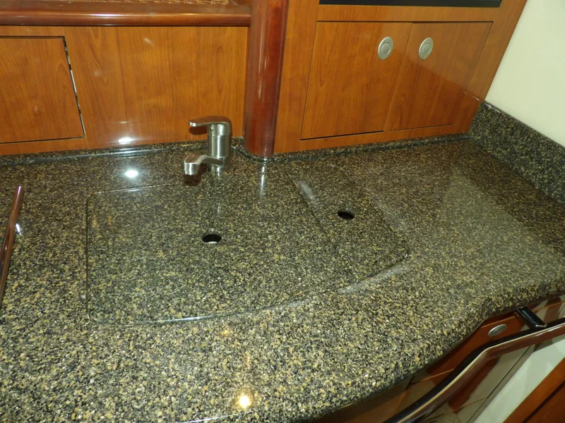 Slide: The Image of 2005 Sea Ray 390 Sundancer kitchen sink with granite countertop and wooden cabinets. - 39