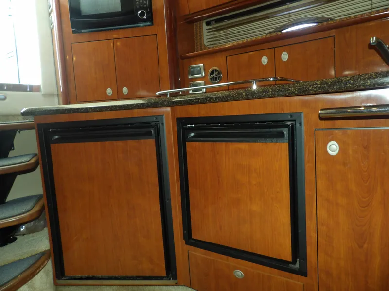Slide: The Image of 2005 Sea Ray 390 Sundancer kitchen with wooden cabinets and appliances. - 43