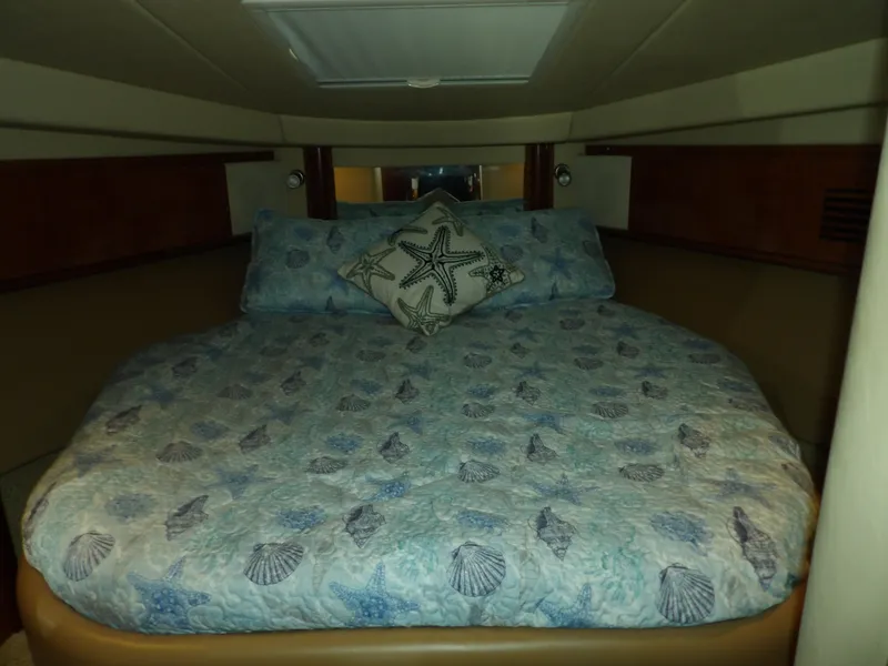 Slide: The Image of Cozy bedroom in 2005 Sea Ray 390 Sundancer with seashell-themed bedding. - 48