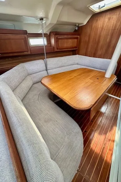 Slide: The Image of Interior of 1993 Hunter Legend 40.5 sailboat with wooden table and cushioned seating. - 12