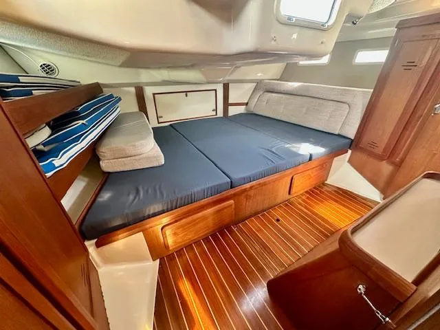 Slide: The Image of 1993 Hunter Legend 40.5 yacht interior with wooden flooring and cozy sleeping area. - 13
