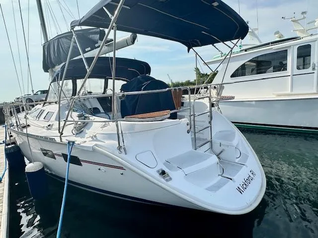 Slide: The Image of 1993 Hunter Legend 40.5 sailboat docked, featuring a sleek design and blue canopy. - 3