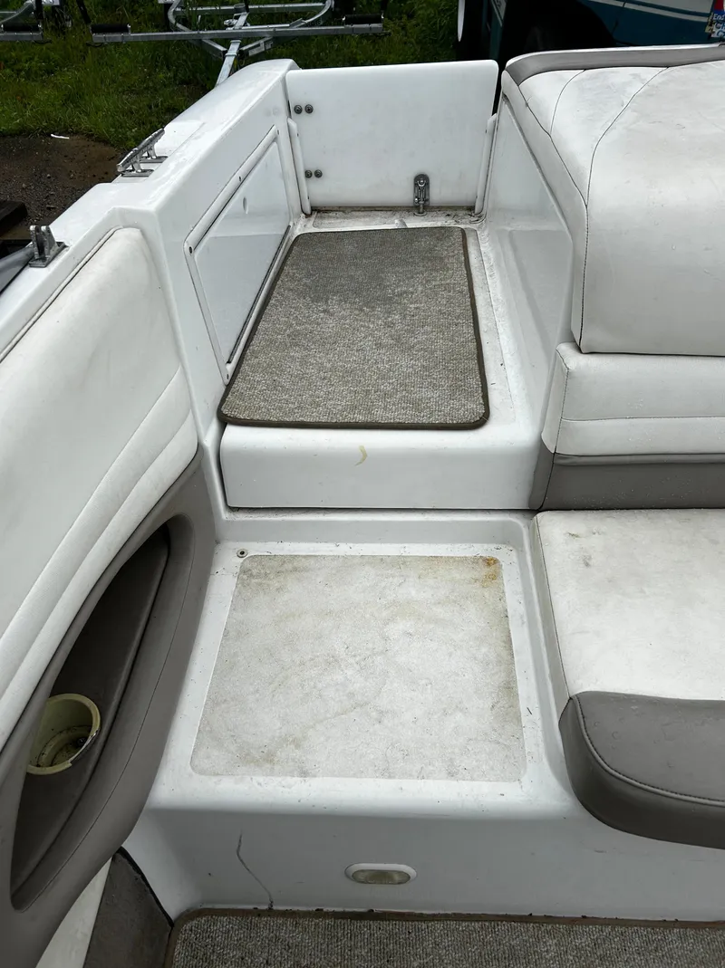Slide: The Image of 2001 Cobalt 226 boat interior with white and gray seating and storage compartments. - 14