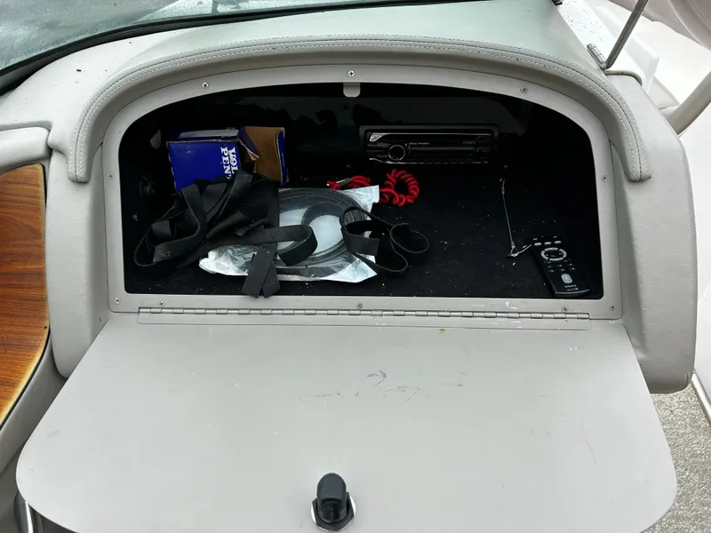 Slide: The Image of Open glove compartment of a 2001 Cobalt 226 boat with various items inside. - 23
