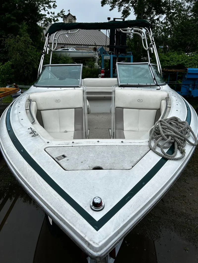 Slide: The Image of 2001 Cobalt 226 boat with white and green trim, docked outdoors. - 3