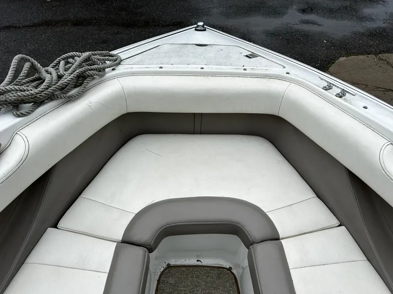Slide: The Image of 2001 Cobalt 226 boat bow seating area with white and gray upholstery. - 34