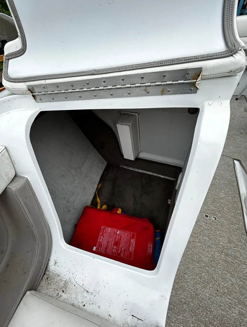 Slide: The Image of Storage compartment in a 2001 Cobalt 226 boat with red life jacket. - 38