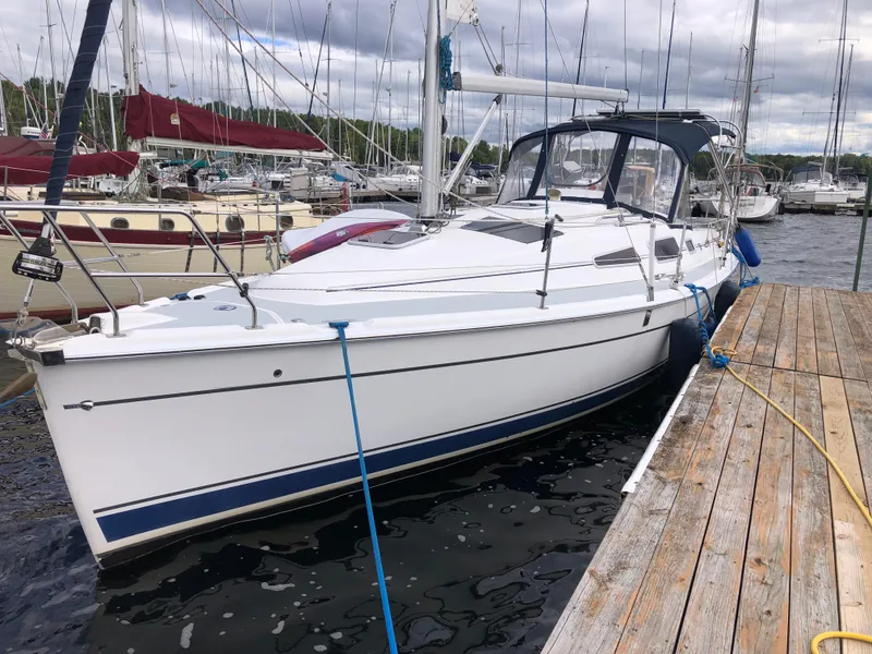 The Image of 2004 Hunter 33 sailboat docked at marina, surrounded by other boats. - 1