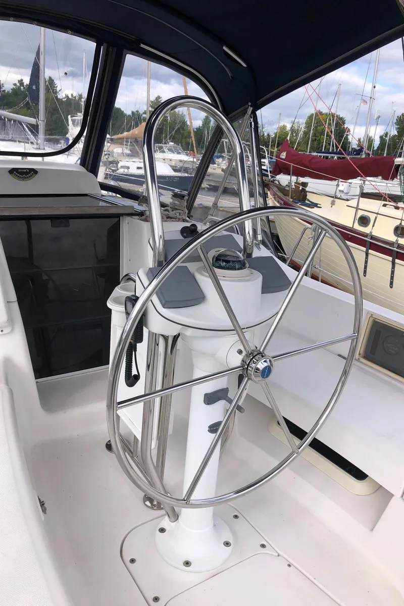 Slide: The Image of 2004 Hunter 33 sailboat cockpit with steering wheel and marina background. - 11