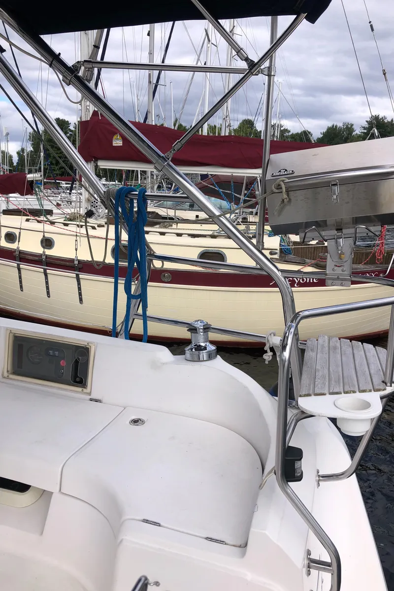 Slide: The Image of 2004 Hunter 33 sailboat docked, featuring cockpit and marina view. - 12