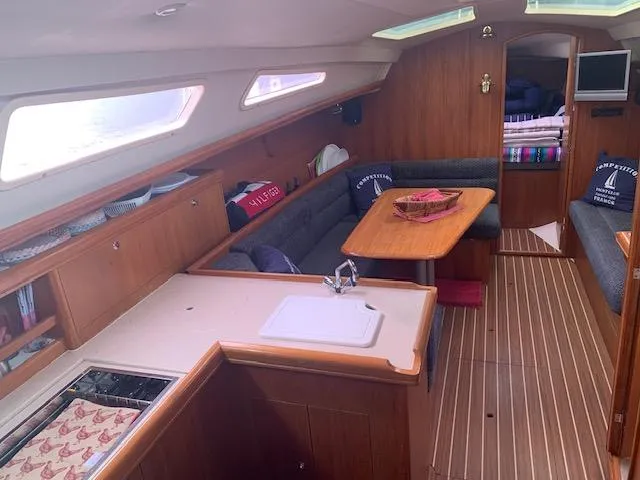 Slide: The Image of Interior of 2004 Hunter 33 sailboat with wood finish and cozy seating area. - 19