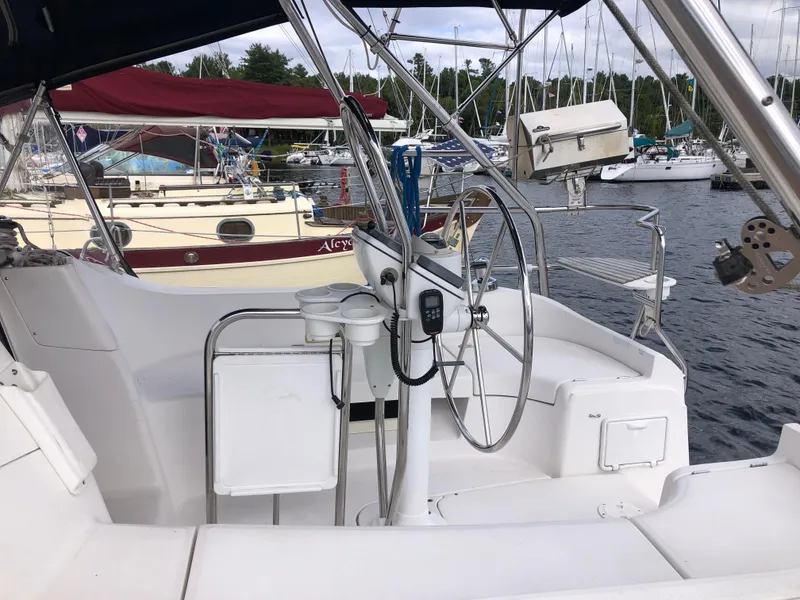Slide: The Image of 2004 Hunter 33 sailboat cockpit with steering wheel, docked at marina. - 2