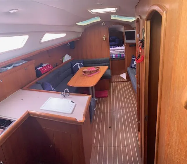 Slide: The Image of Interior of a 2004 Hunter 33 sailboat with wood finish and cozy seating area. - 20