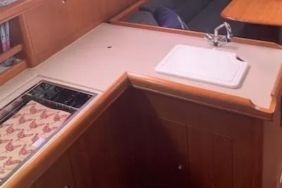 Slide: The Image of 2004 Hunter 33 yacht interior kitchen with sink and wooden cabinetry. - 21