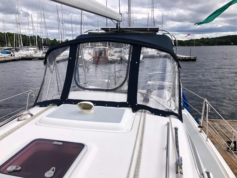 Slide: The Image of 2004 Hunter 33 sailboat docked at a marina with clear cockpit enclosure. - 3