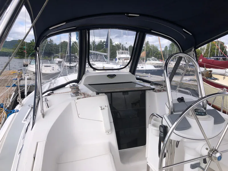 Slide: The Image of 2004 Hunter 33 sailboat cockpit with steering wheel and canopy, docked at marina. - 4