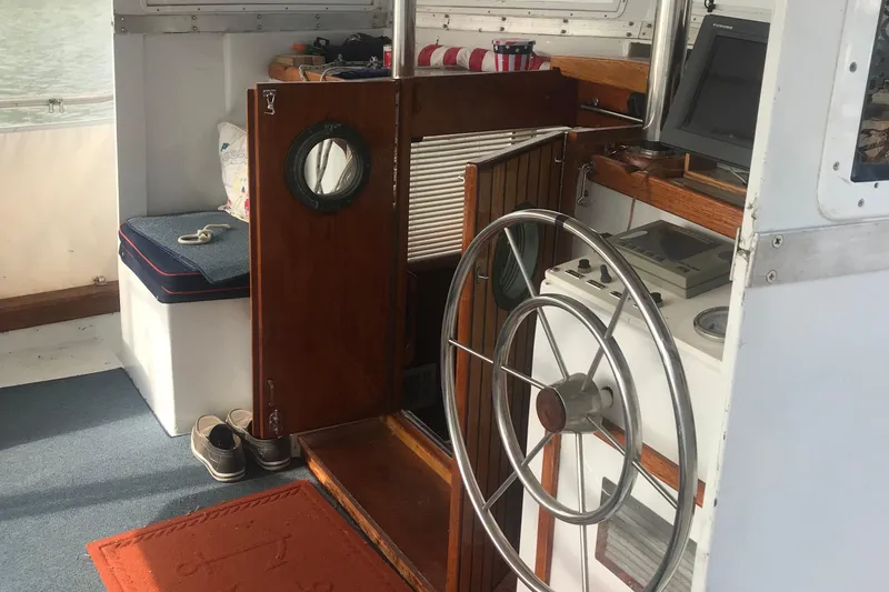 Slide: The Image of Interior of 1984 Custom 43 Steady Sailor with helm, wooden door, and nautical decor. - 10