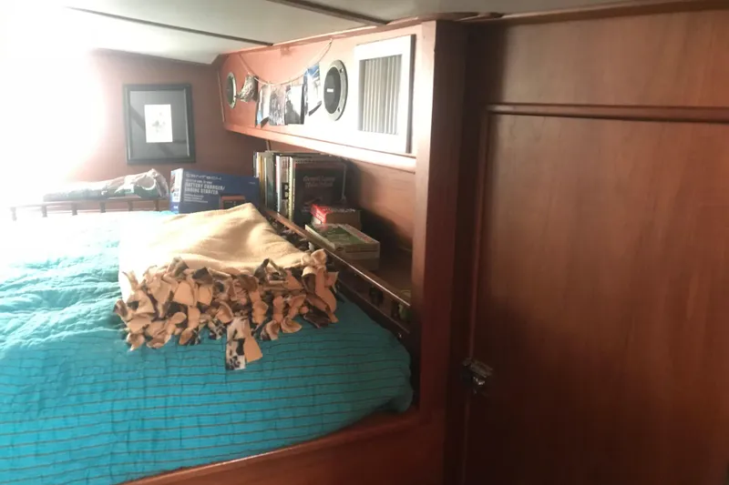 Slide: The Image of Cozy cabin interior of 1984 Custom 43 Steady Sailor with bed and wooden shelves. - 23