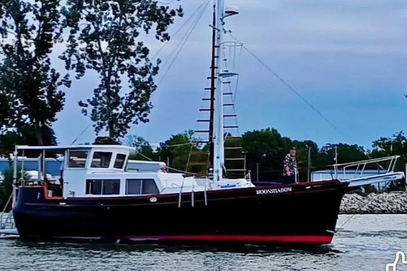 Slide: The Image of Custom 1984 43 Steady Sailor boat named "Moonshadow" on calm waters near trees. - 28