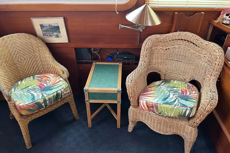 Slide: The Image of Wicker chairs with colorful cushions and a small table inside a 1984 Custom 43 Steady Sailor. - 33
