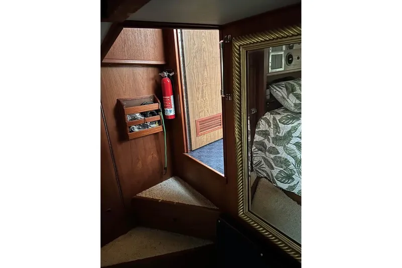 Slide: The Image of Interior of 1984 Custom 43 Steady Sailor with fire extinguisher and floral bedding. - 35