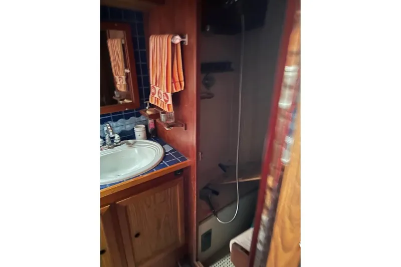 Slide: The Image of Compact bathroom in 1984 Custom 43 Steady Sailor yacht with sink, mirror, and shower. - 36