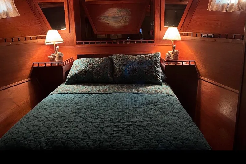 Slide: The Image of Cozy cabin bedroom in 1984 Custom 43 Steady Sailor yacht with warm lighting and quilted bedding. - 5