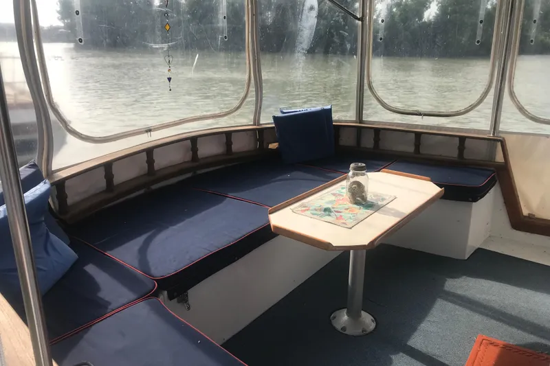 Slide: The Image of Cozy seating area on 1984 Custom 43 Steady Sailor boat with blue cushions and table. - 8