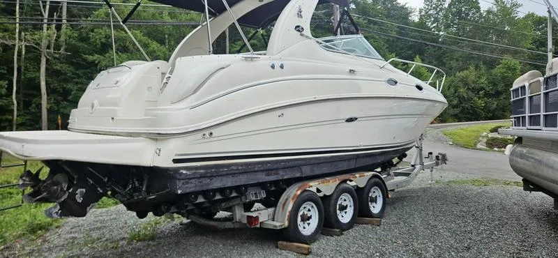 Slide: The Image of 2001 Sea Ray Sundancer 280 on a triple-axle trailer, parked outdoors. - 2