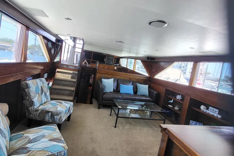 Slide: The Image of 1970 Chris-Craft Commander interior with modern seating, glass table, and nautical decor. - 10