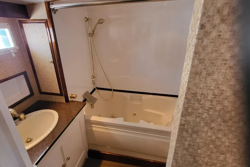 Slide: The Image of 1970 Chris-Craft Commander bathroom with sink, countertop, and bathtub with showerhead. - 17