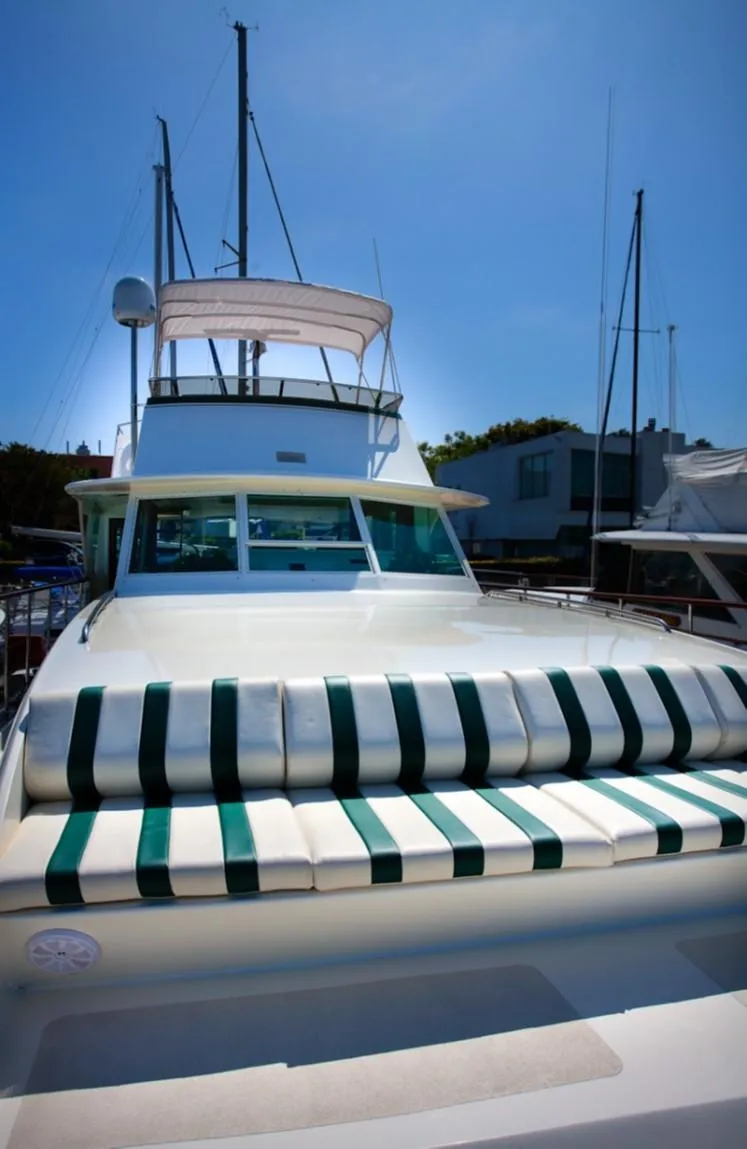 Slide: The Image of 1970 Chris-Craft Commander yacht with striped seating, docked under clear blue sky. - 3
