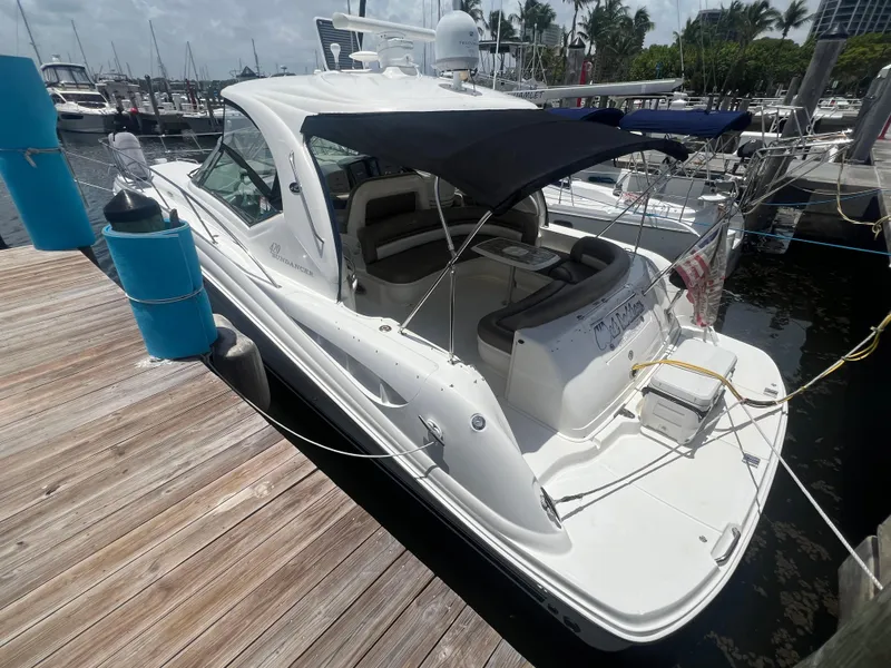 Slide: The Image of 2005 Sea Ray 420 Sundancer docked at marina, featuring sleek design and spacious deck. - 1