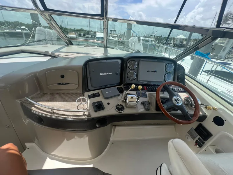 Slide: The Image of 2005 Sea Ray 420 Sundancer helm with navigation screens and steering wheel. - 18