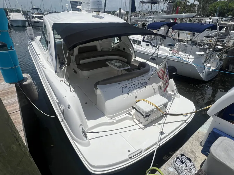 Slide: The Image of 2005 Sea Ray 420 Sundancer docked at marina, featuring spacious deck and seating area. - 2