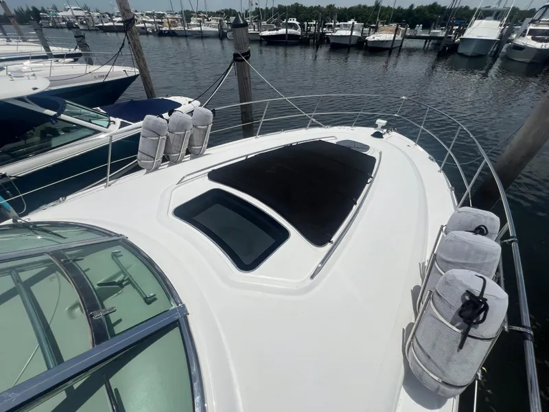 Slide: The Image of 2005 Sea Ray 420 Sundancer yacht docked at marina, featuring sleek design and spacious deck. - 21