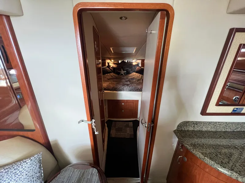 Slide: The Image of Interior cabin view of 2005 Sea Ray 420 Sundancer yacht, featuring cozy bedroom and elegant wood finishes. - 35