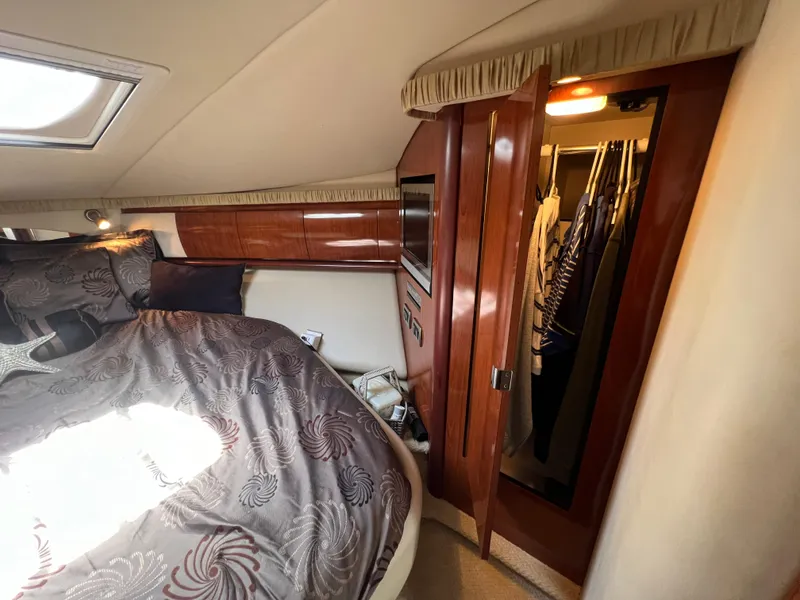 Slide: The Image of Luxurious 2005 Sea Ray 420 Sundancer cabin with elegant bedding and wooden cabinetry. - 43