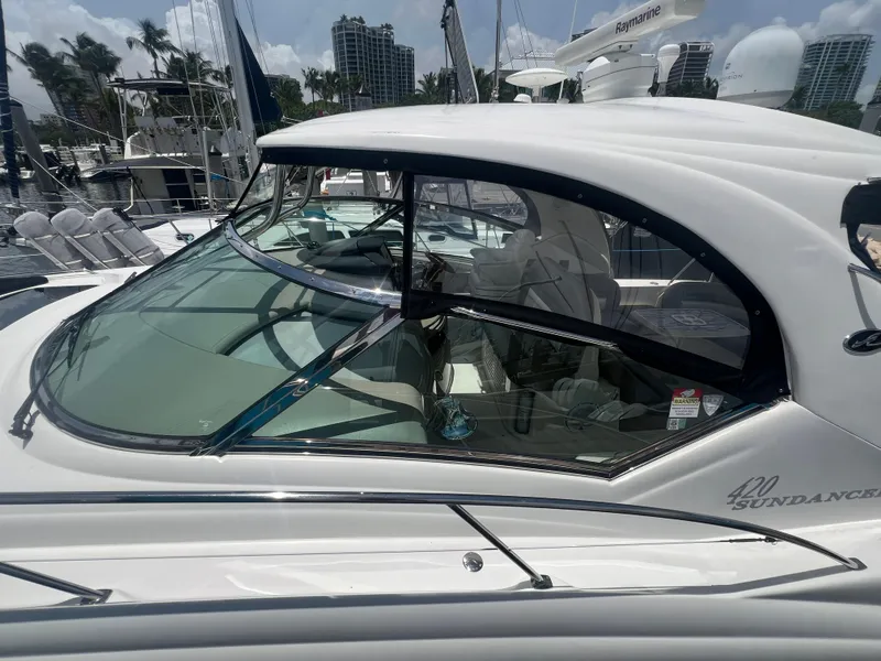 Slide: The Image of 2005 Sea Ray 420 Sundancer yacht docked, showcasing sleek design and spacious cockpit. - 5