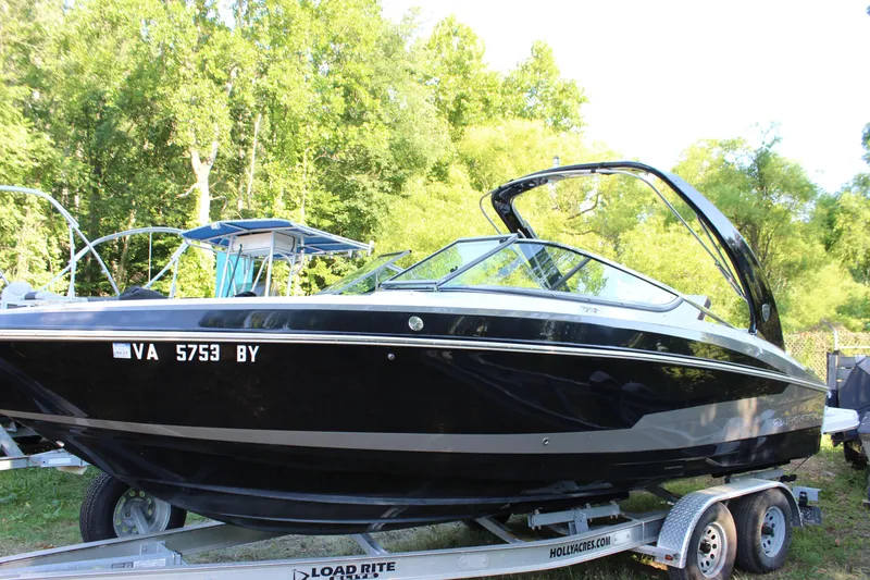 Slide: The Image of 2016 Regal 2500 Bowrider boat on a trailer in a wooded area. - 16