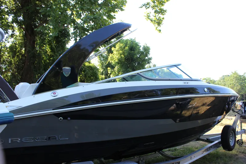 Slide: The Image of 2016 Regal 2500 Bowrider boat on a trailer, side view with trees in the background. - 18