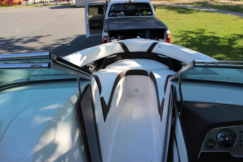 Slide: The Image of 2016 Regal 2500 Bowrider boat interior with open bow and truck in background. - 46
